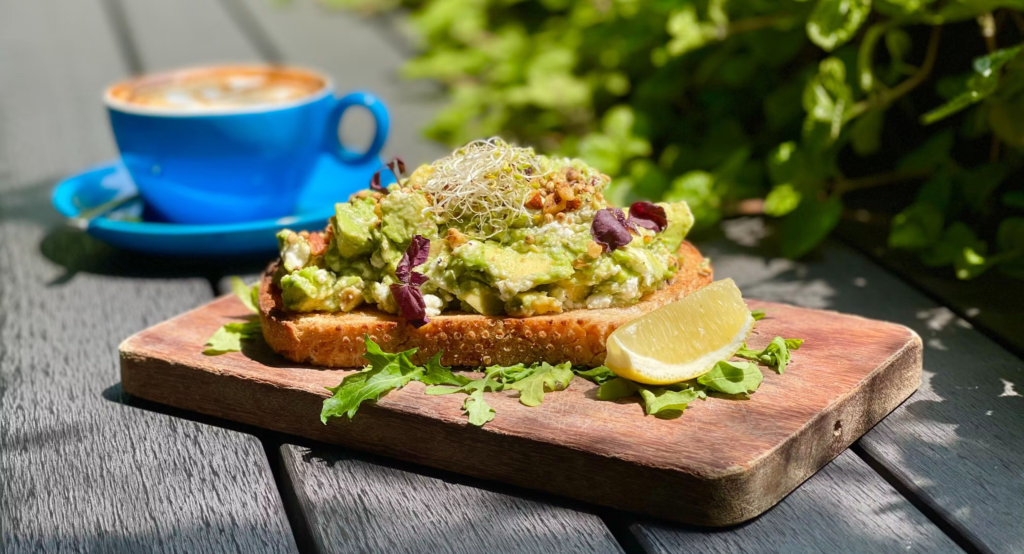 Smashed avocado toast served with hot coffee at a Halal-certified café in Singapore.