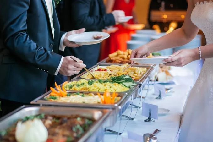 Guests serving food from buffet trays for Private Event Catering in Singapore setups.