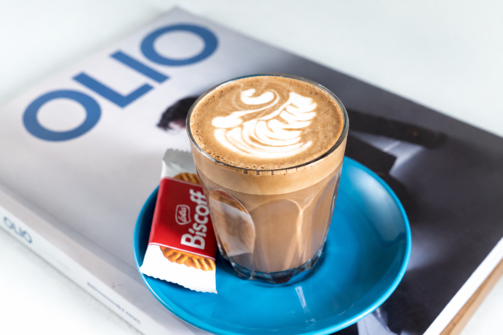 Glass of latte with swan art and Biscoff biscuit for Event coffee setup Singapore.